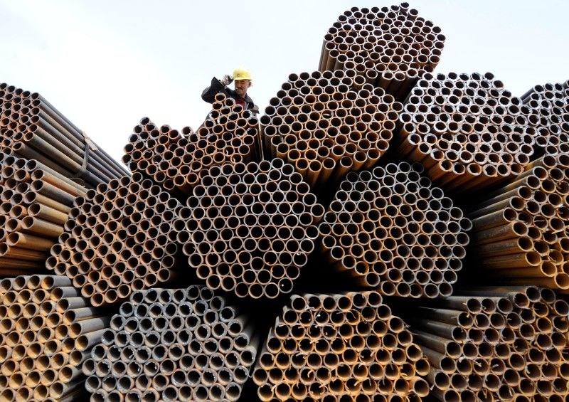 A labourer is seen on top of steel pipes at a steel market in Taiyuan, Shanxi province April 10, 2010. u00e2u20acu201d Reuters pic