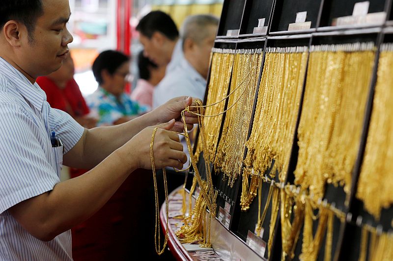 A salesman chooses gold chains for people buying gold at a gold shop in Bangkok's Chinatown June 8, 2016. u00e2u20acu201d Reuters pic