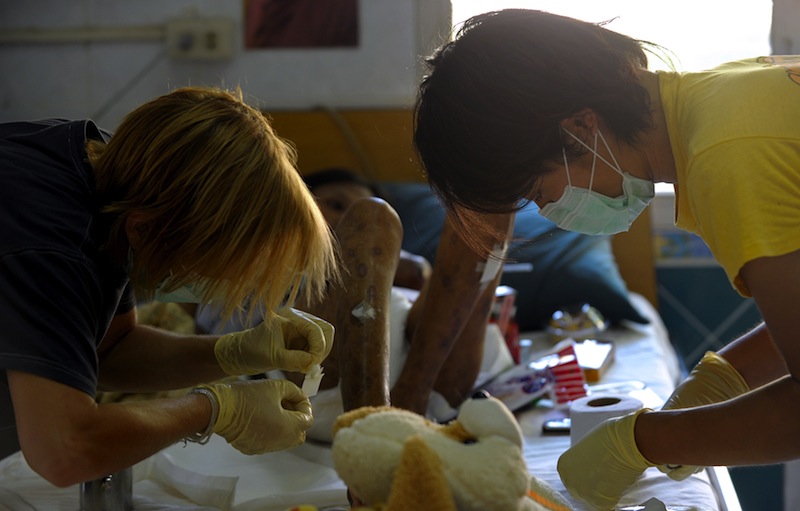This photo taken on November 28, 2010 shows foreign volunteers giving medical treatment to an AIDS patient at a hospice at an Buddhist temple in Lopburi province, 150km north of Bangkok. u00e2u20acu201d AFP pic