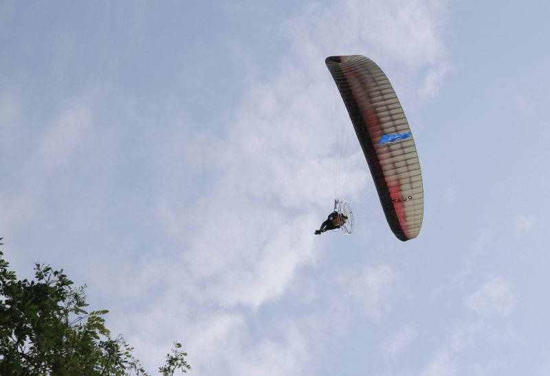 Paragliders carrying flags of Umno and Barisan Nasional coast over the Dewan Jubli Perak in Kuala Kangsar, on the nomination day in the Kuala Kangsar by-election. u00e2u20acu2022 Picture by Marcus Pheong