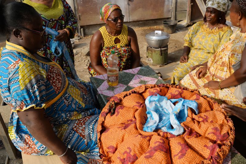 Women sit next to a u00e2u20acu02dcpot in a bagu00e2u20acu2122, a clever new fad to stew up a tasty rice and tomatoes, that could help fight climate change, on May 31, 2016, in Douala. u00c2u00a9AFP PHOTO/REINNIER KAZE