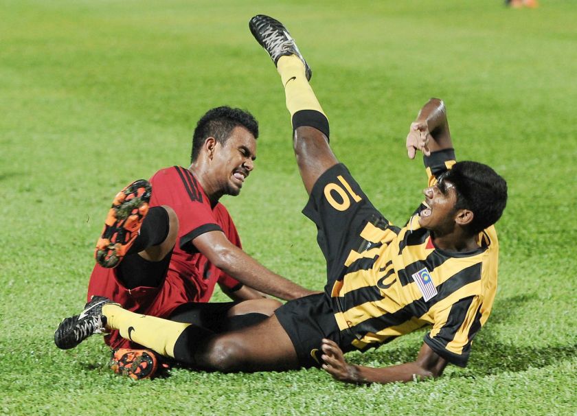 Pemain Malaysia, S Kumaahran (kanan) dijatuhkan pemain Timor Leste, Filipe Oliveira pada perlawanan kalah mati kedua kelayakan Piala Asia 2019 di stadium Larkin, 6 Jun 2016. u00e2u20acu201d Foto Bernama
