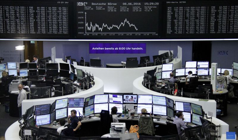 Traders work at their desks in front of the German share price index, DAX board, at the stock exchange in Frankfurt June 8, 2016. REUTERS/Staff/Remote 