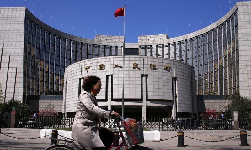 A woman rides past the headquarters of the Peopleu00e2u20acu2122s Bank of China (PBOC), the central bank, in Beijing, April 3, 2014. u00e2u20acu201d Reuters pic 