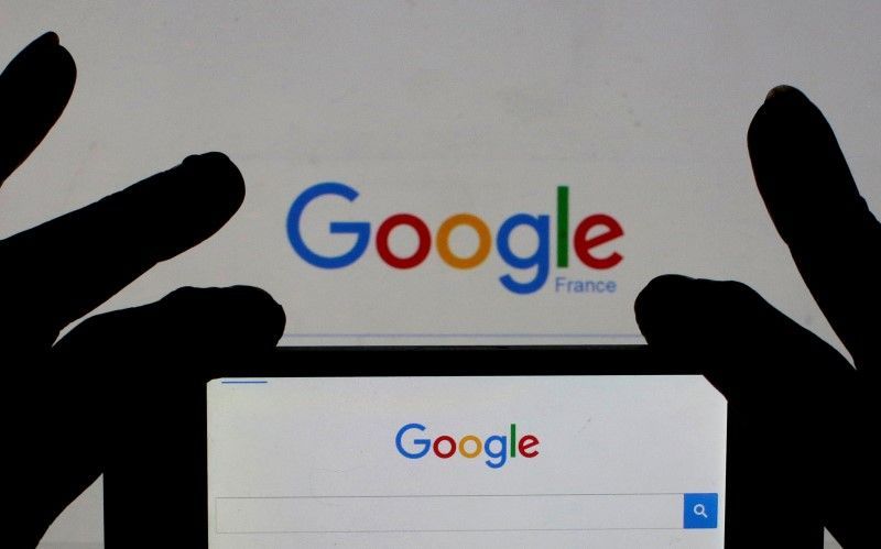 A woman holds her smart phone which displays the Google home page, in this picture illustration taken February 24, 2016. REUTERS/Eric Gaillard/Illustration
