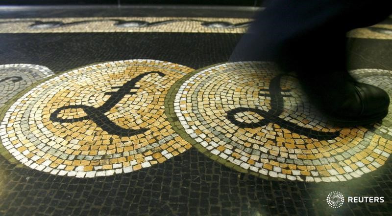 An employee is seen walking over a mosaic of pound sterling symbols set in the floor of the front hall of the Bank of England in London, in this March 25, 2008 file photograph. u00e2u20acu201d Reuters pic