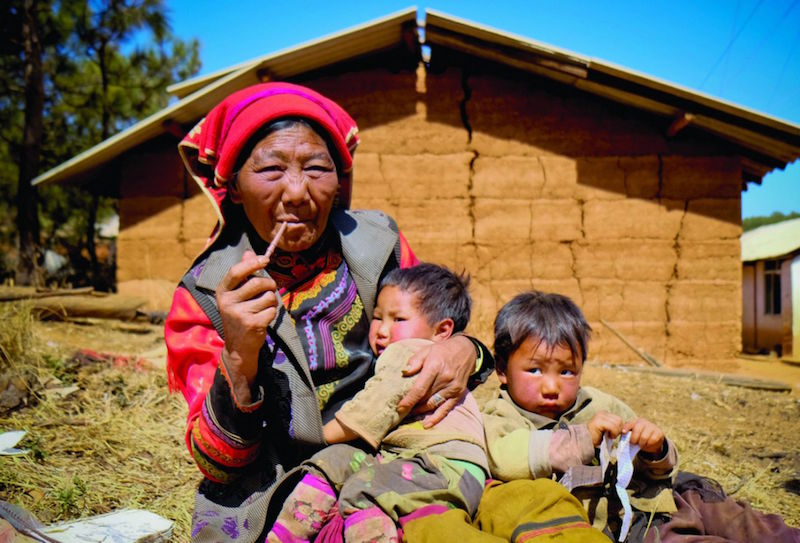 An old Yi minority woman dressed in a traditional ethnic garb, smoking a pipe at Shaxi, Yunnan province. — TODAY pic