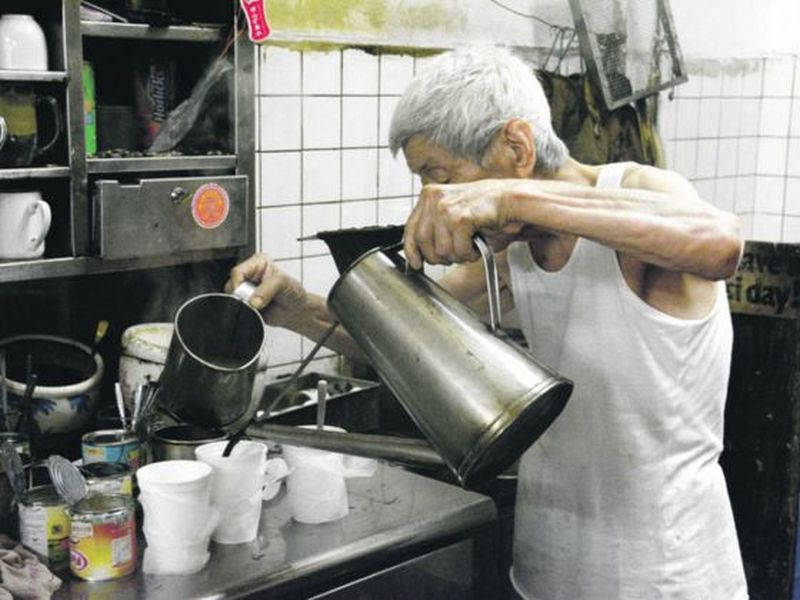 The owner of Heap Seng Leong, eighty-year-old Shi Pong preparing his coffee.