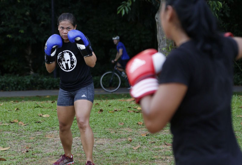 A female participant hits it at a Spartan Beach Boxing Bootcamp, one of the classes offered by the Spartans Boxing Club. — TODAY pic