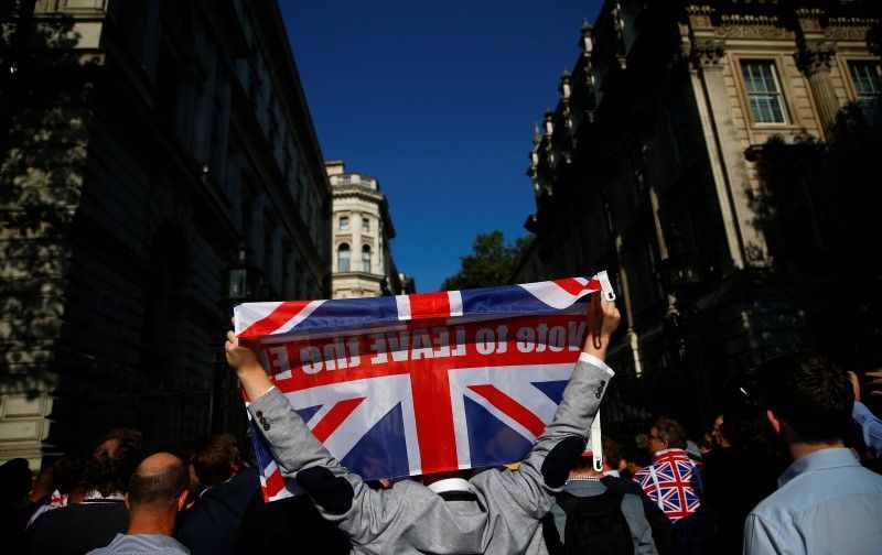 A vote-leave supporter holds a Union flag, following the result of the EU referendum, outside Downing Street in London June 24, 2016. REUTERS/Neil Hall