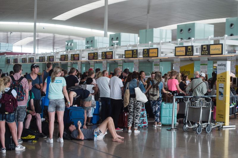 Passengers queue in front of Spanish low-cost airline Vueling check-in counters at the El Prat Airport in Barcelona on July 5, 2016. u00e2u20acu2022 AFP pic
