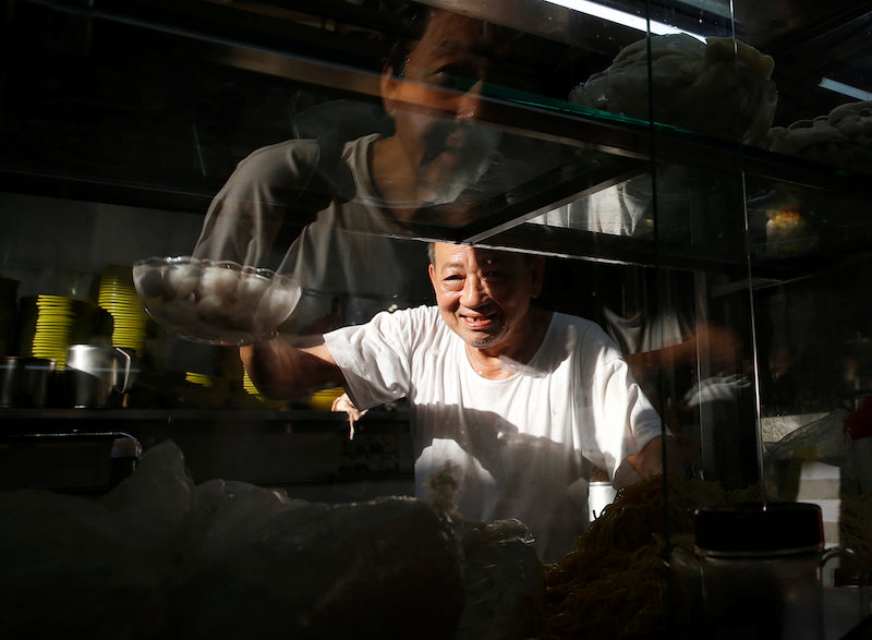 A hawker cooks fishball noodles at his stall at a hawker centre in Singapore May 21, 2016. u00e2u20acu201d Reuters pic