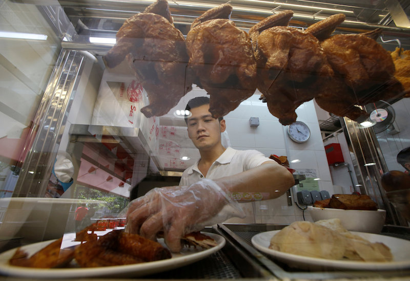Hawker Derrick Lee, 30, sells chicken rice in his stall at a hawker centre in Singapore June 30, 2016. — Reuters pic