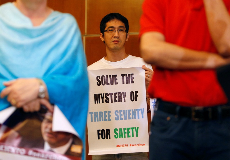 A family member of a passenger on board the missing Malaysia Airlines flight MH370 holds a placard during a news conference following a meeting with Joint Agency Coordination Centre (JACC) in Kuala Lumpur, Malaysia July 21, 2016. u00e2u20acu201d Reuters pic
