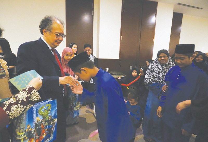 Datuk Johari Razak presents duit Raya and goodie bags to orphans.