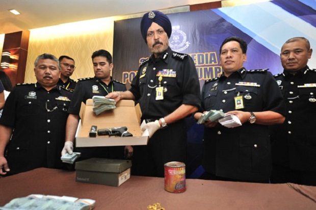 City police chief Datuk Amar Singh shows the gun used in the Taman OUG shooting and the cash recovered from the RTD robbery. u00e2u20acu201d Picture by Malay Mail