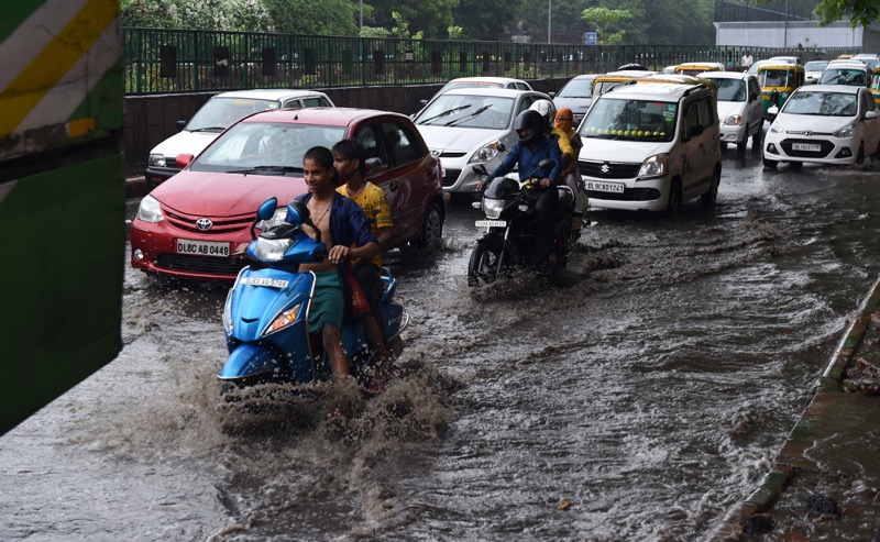 Indian commuters travel through floodwaters on a street of New Delhi on July 9, 2015, after heavy monsoon rainfall. u00e2u20acu2022 AFP pic