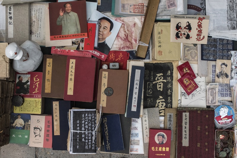 Books, coins and Mao era objects on display at the Panjiayuan Antique Market in Beijing, July 9, 2016. — Picture by Gilles Sabrie/The New York Times