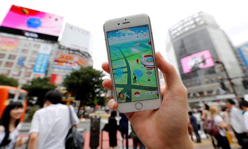A man poses with his mobile phone displaying the augmented reality mobile game 'Pokemon Go' by Nintendo in front of a busy crossing in Shibuya district in Tokyo, Japan, July 22, 2016. u00e2u20acu201du00c2u00a0Reuters pic