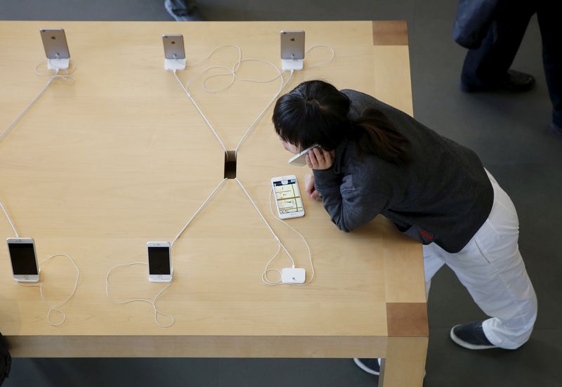 A woman uses her smart phone at an Apple store in Beijing November 2, 2015. u00e2u20acu201d AFP pic