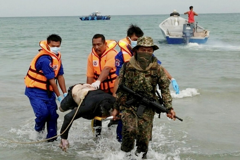 Civil defence and military personnel retrieving the body of a victim of the capsized boat, in Pantai Batu Layar, Sungai Rengit, Kota Tinggi, July 26, 2016. u00e2u20acu201d Bernama pic