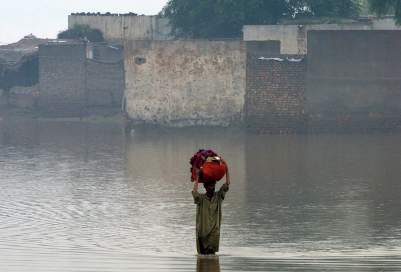 A Pakistani man wades through a flooded area in Nowshera district, in Khyber Pakhtunkhwa province August 3, 2015. This area in recent years has been prone to flooding blamed on climate change. u00e2u20acu201d AFP pic