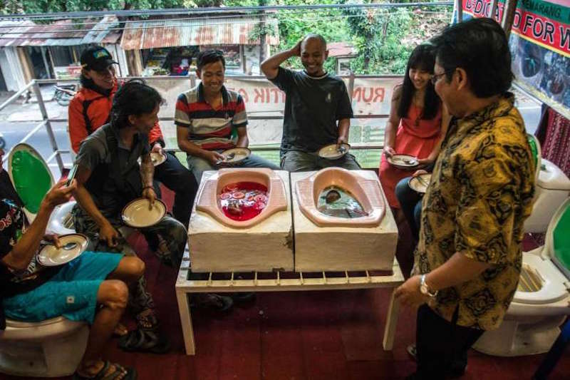 Customers have a meal at the ‘Jamban Cafe’ in the city of Semarang July 16, 2016. — AFP pic