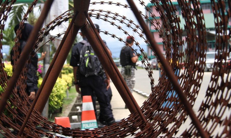 Anggota Unit K9 memeriksa kenderaan keluar masuk Penjara Kota Kinabalu ketika Mahkamah Tinggi menjatuhkan hukuman penjara seumur hidup terhadap sembilan penjenayah rakyat Filipina yang melancarkan perang terhadap Yang di-Pertuan Agong dan menjejaskan kehi