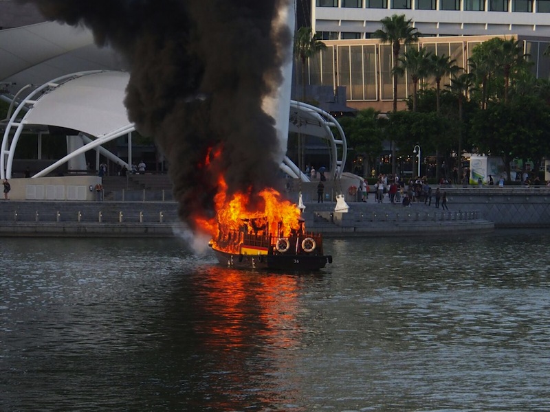 The boat on fire in Marina Bay on July 12, 2016. Photo submitted by reader Luke. u00e2u20acu201d TODAY pic