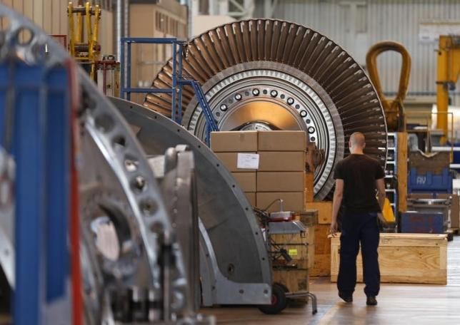 A worker walks past a gas turbine under construction at the gas turbines production unit of the General Electric plant in Belfort, June 24, 2014. REUTERS/VINCENT KESSLER