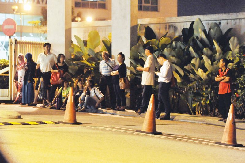 A long queue starts to form at the main gate as they wait for security personnel to allow them in.
