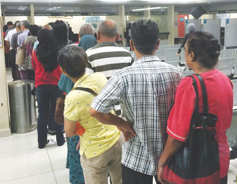 Many stay in line to get their numbers, hoping to get their passports on the same day. u00e2u20acu2022 Malay Mail pic