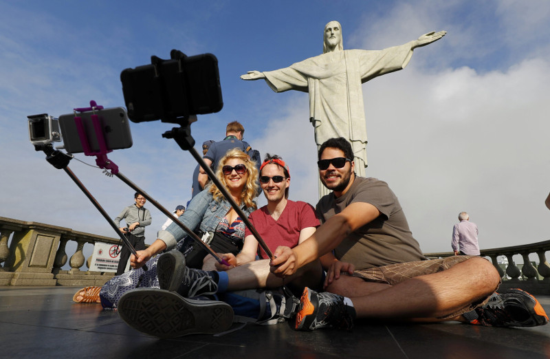 Tourists pose for selfies in front of Christ the Redeemer in Rio de Janeiro, July 30, 2016. u00e2u20acu201d Reuters pic
