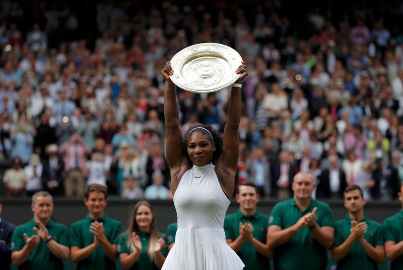 Serena Williams celebrates winning her women's singles final match against Germany's Angelique Kerber with the trophy at Wimbledon July 9, 2016. u00e2u20acu2022 Reuters pic