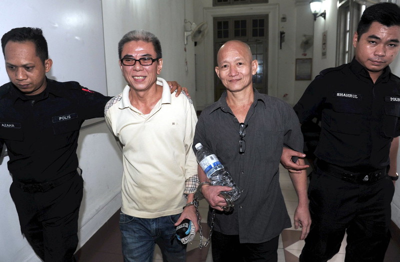 Police personnel leading away Tan Teck Seng, 48, (left) and Ng Cheng Boon, 49, after they were sentenced to life imprisonment by the High Court in Johor Baru, on July 25, 2016. u00e2u20acu201d Bernama pic