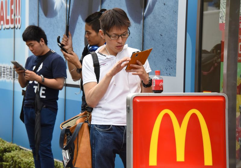 People use their mobile phones to play Nintendou00e2u20acu2122s Pokemon Go game in front of a McDonaldu00e2u20acu2122s restaurant at Akihabara shopping district in Tokyo on July 22, 2016. TORU YAMANAKA / AFP
