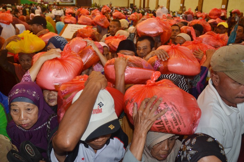 Indonesian people carry supplies which they received as charity for the needy in Malang, East Java on June 19, 2016. u00e2u20acu201d AFP pic