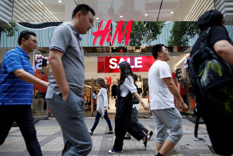 People walk past a H&M fashion chain store at Tsim Sha Tsui shopping district in Hong Kong August 1, 2016. u00e2u20acu201d Reuters