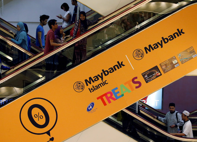 People take an escalator with Maybank advertisement at a mall in Kuala Lumpur August 27, 2016. u00e2u20acu201d Reuters pic