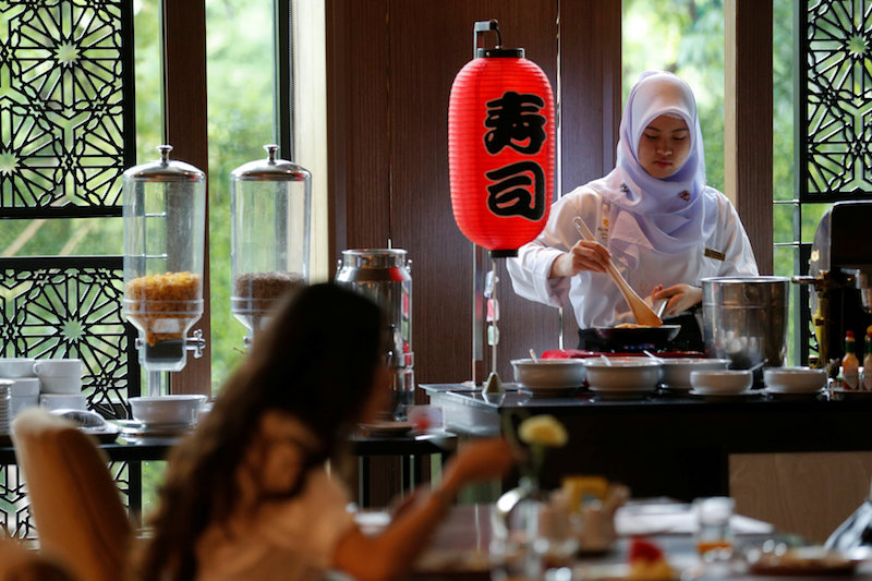 A Muslim employee cooks as a visitor has breakfast at the Al Meroz hotel in Bangkok August 29, 2016. — Reuters pic 