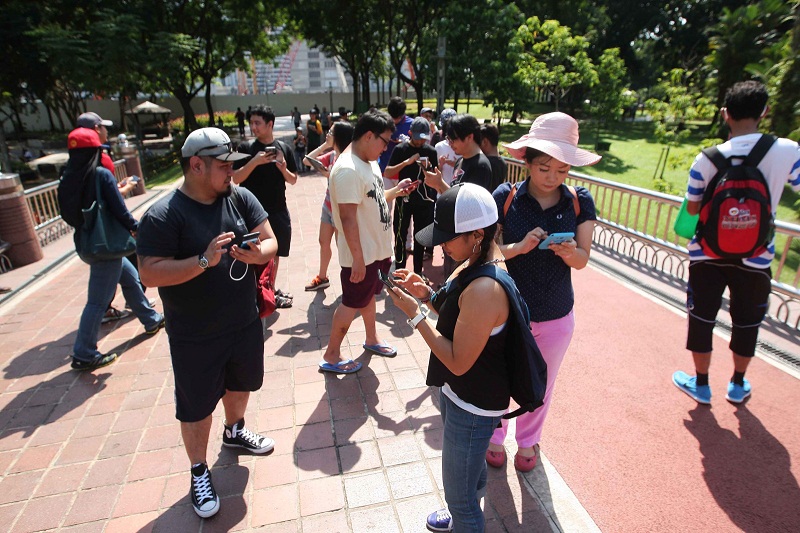 Li (second from right) hunting for Pokemons with her new friends at KLCC yesterday. u00e2u20acu201d Picture by Hari Anggara