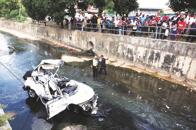 The mangled car after it crashed through a railing and landed in the monsoon drain. u00e2u20acu201d Picture by Malay Mail