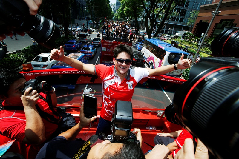 Singaporeu00e2u20acu2122s Olympic gold medallist swimmer Joseph Schooling poses for photos during a victory parade on an open top bus along Orchard Road in Singapore August 18, 2016. u00e2u20acu201d Reuters pic
