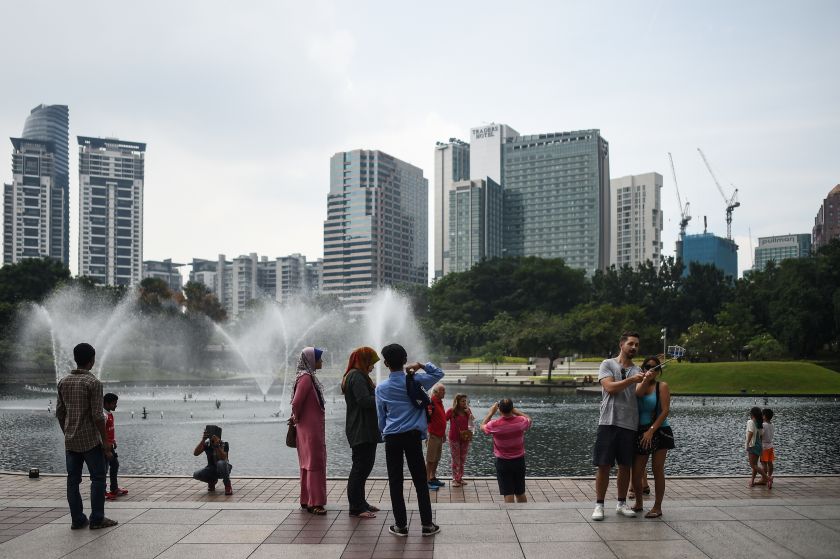 Tourists take pictures in a park in Kuala Lumpur on August 13, 2016. u00e2u20acu201d AFP pic