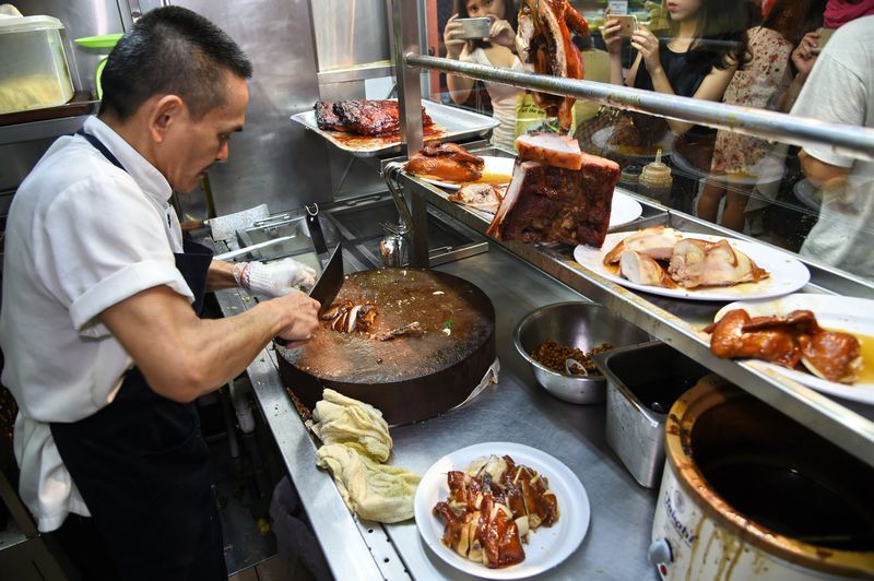 This photo taken on July 26, 2016 shows Singaporean hawker Chan Hon Meng chopping braised chicken at his Hong Kong Soya Sauce Chicken Rice and Noodle stall in Singapore. u00e2u20acu201d AFP pic