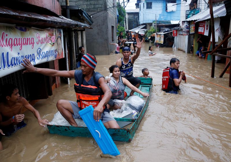 Residents ride on a makeshift boat after evacuating their homes due to flooding brought by monsoon rains in San Mateo, Rizal, Philippines August 13, 2016. u00e2u20acu201d Reuters pic