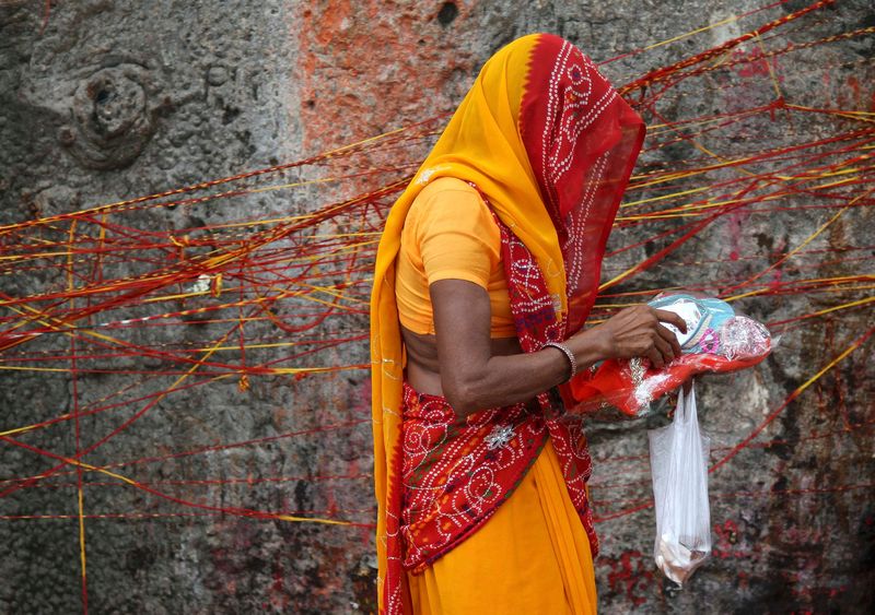 A Hindu woman carrying religious offerings walks past a Kalpavriksha tree, believed to be a divine wishing tree, during a festival on the outskirts of Ajmer, India August 2, 2016. u00e2u20acu201d Reuters pic