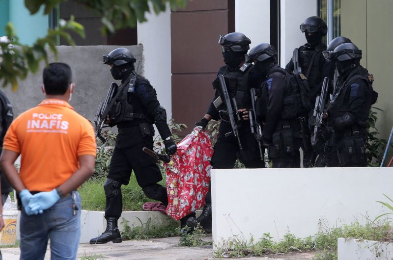 Indonesian anti-terror police carry a bag containing a suspected firearm and other evidence from a building during a raid in Batam, Riau Islands, August 5, 2016. Antara Foto/M N Kanwa/via REUTERS