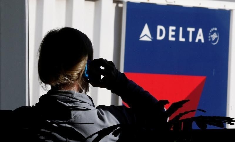 A passenger talks on her phone at a Delta Air Lines gate a day before the annual Thanksgiving Day holiday at the Salt Lake City international airport, in Salt Lake City, Utah, November 21, 2012. REUTERS/George Frey/File Photo
