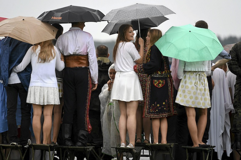 People sit atop chairs as they watch Pope Francis' departure at Balice airport near Krakow, Poland July 31, 2016. u00e2u20acu201d Reuters pic